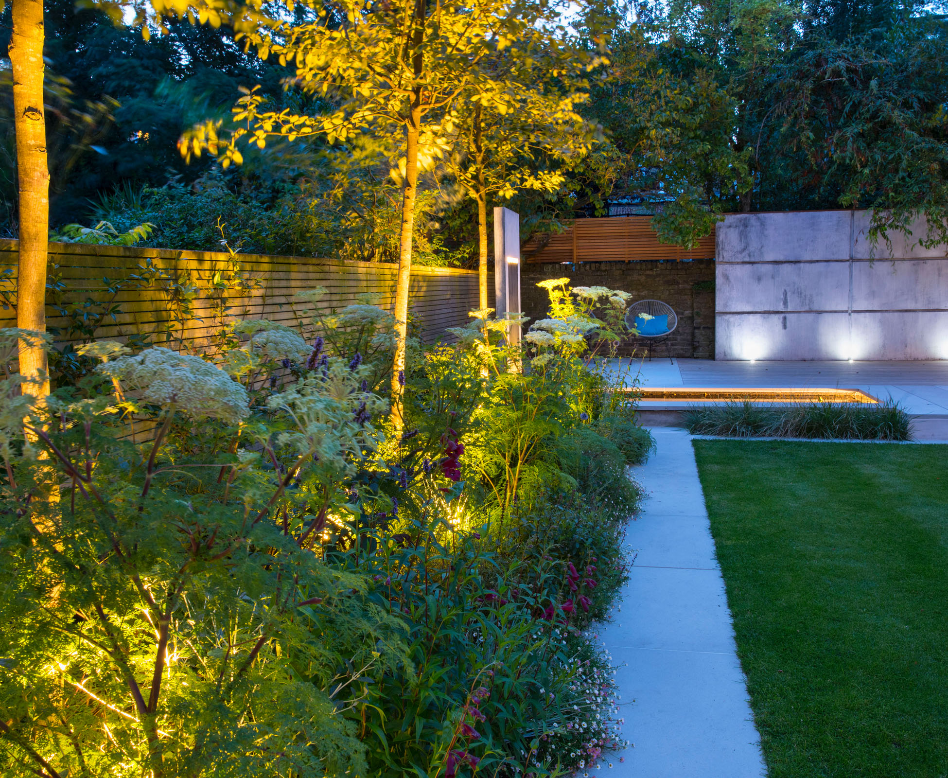 The focal zinc panel becomes a strong feature from the house when night comes and the lights are turned on. The soft light in the planting attracts your eye to the end of the garden, giving this Islington garden more depth.