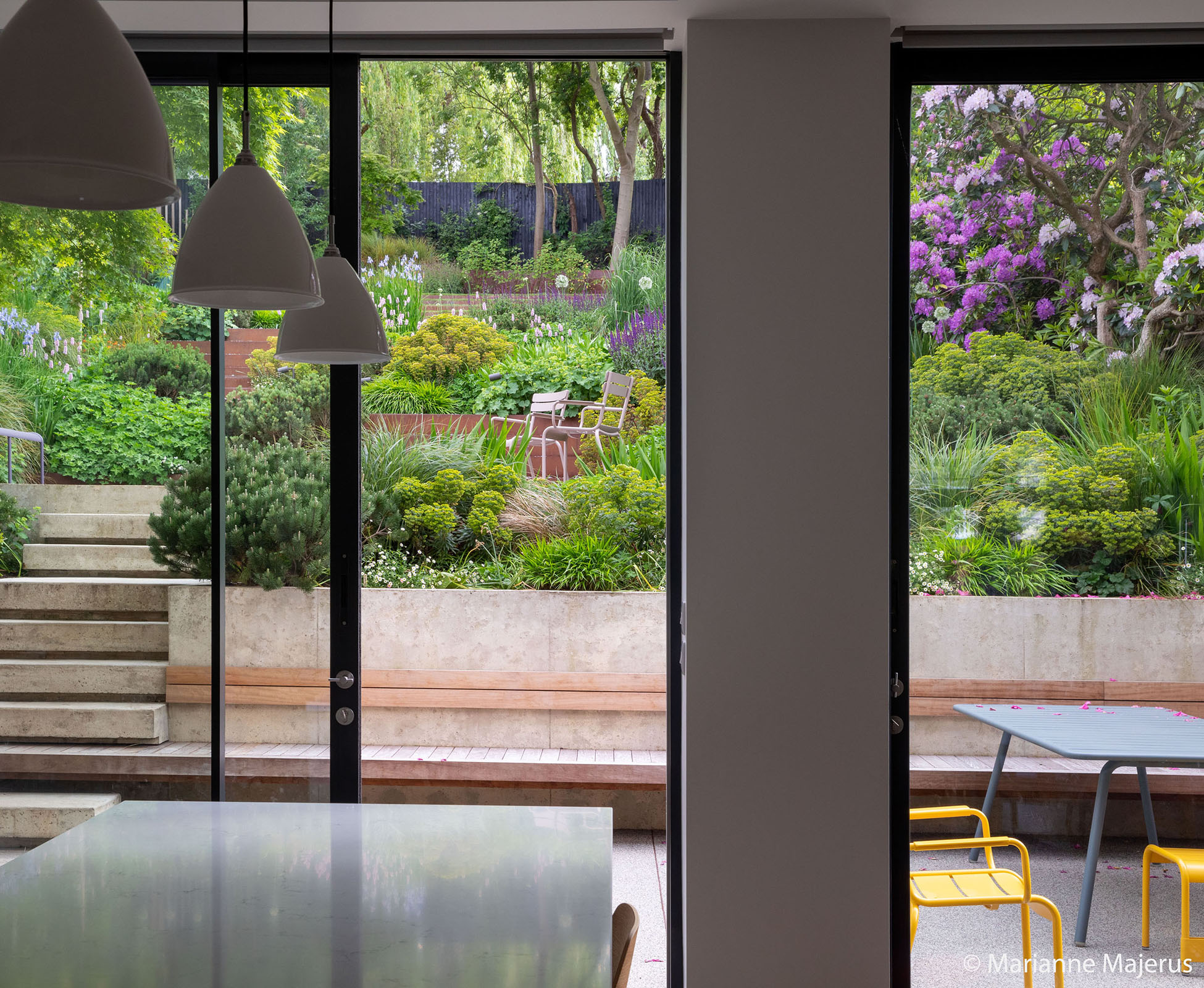 Theatrical view of the garden from the tall sliding doors of the house kitchen, enticing you out to explore.